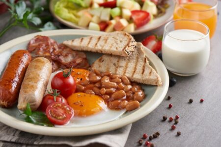 nachystané anglické raňajky na stole obsahujúce fazuľu, vajíčka a klobásy