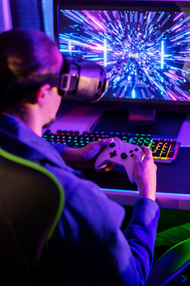 hráč hrá videohry na počítači a na ovládači 