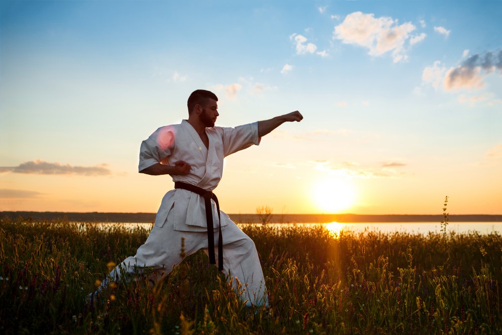 zápasník karate cvičí počas západu slnka