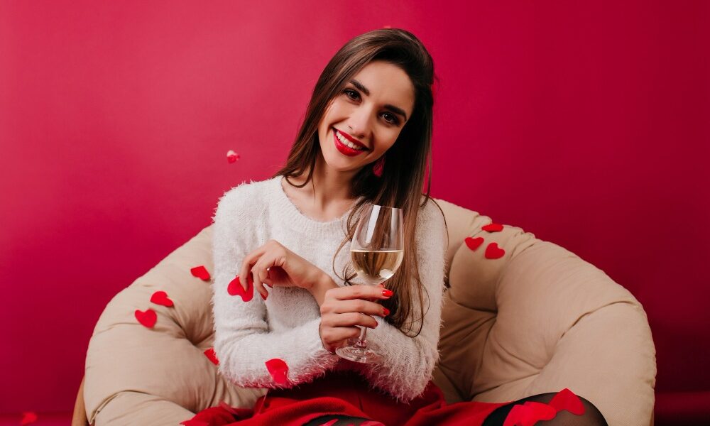 mladá žena trávi sama večer s vínom v ruke