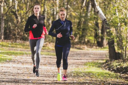 mladé ženy behajú spolu v parku