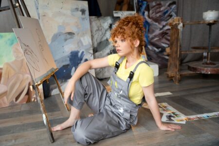 žena sedí na zemi a maľuje